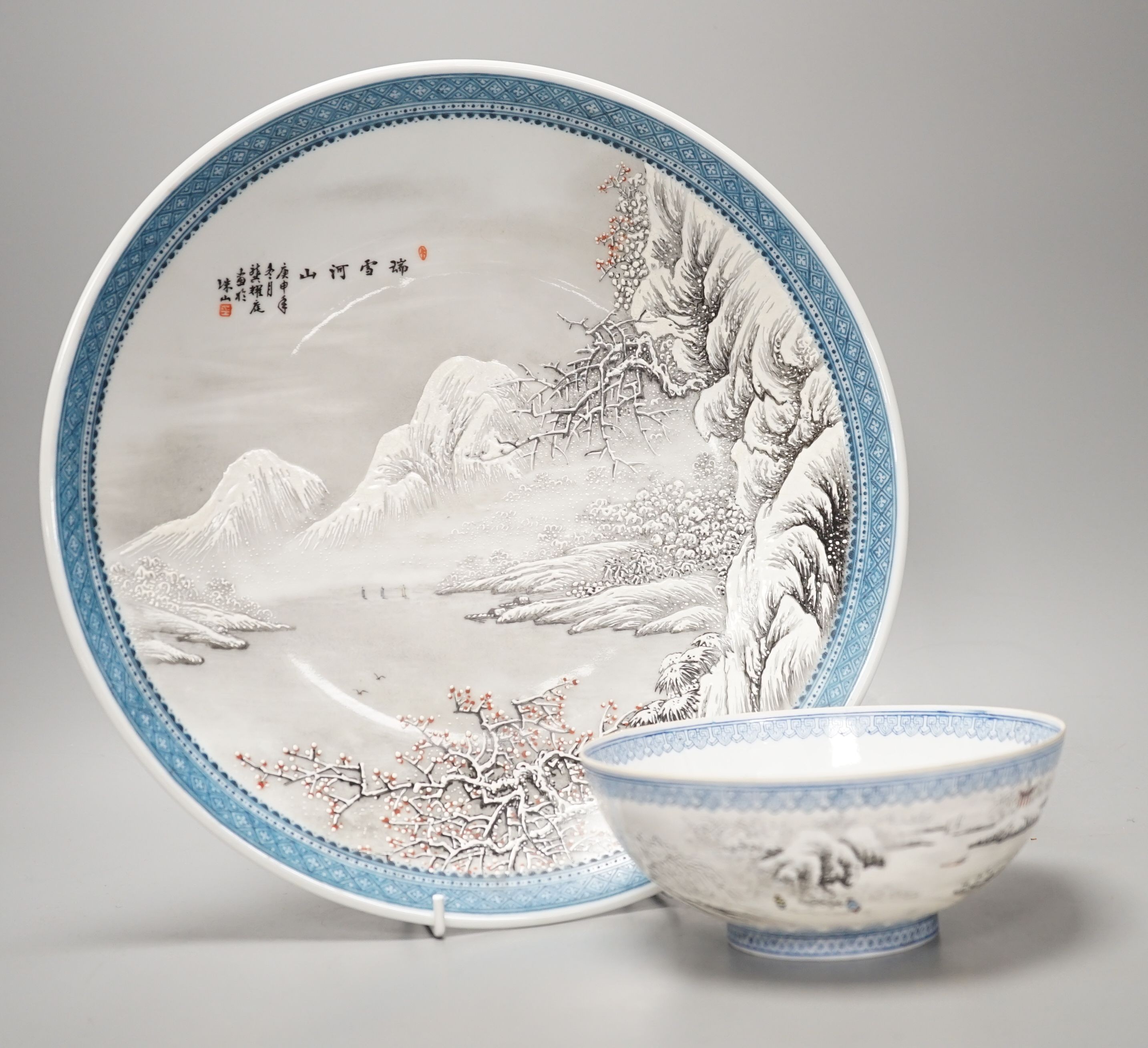 A Chinese enamelled porcelain snow scene dish, diameter 31cm, and a similar smaller eggshell bowl